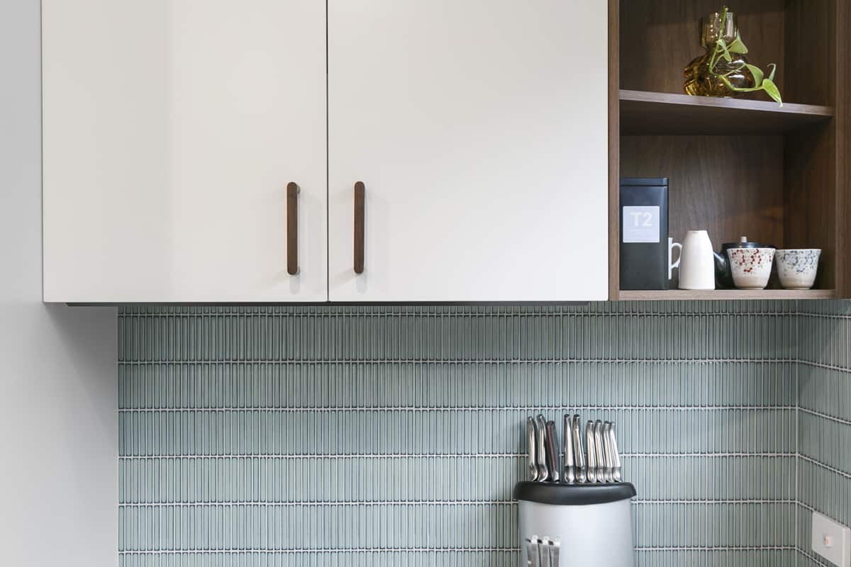 White and wood kitchen units with pale blue wall tiles