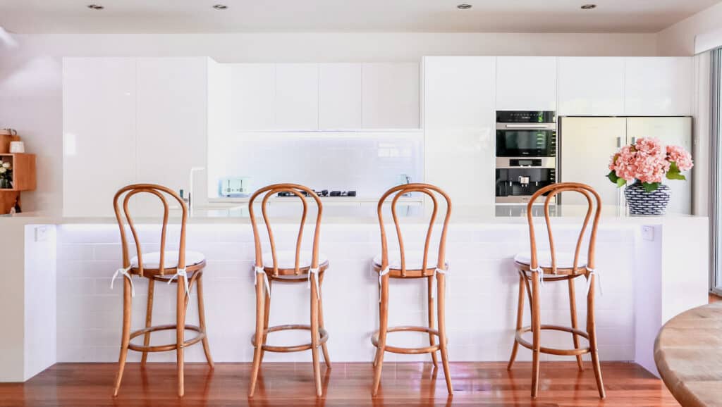 Modern white kitchen with wooden bar stools