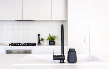 Close-up of black tap in a modern white kitchen renovation