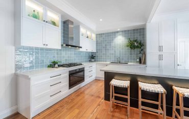 White kitchen units and blue wall tiles in a modern kitchen renovation